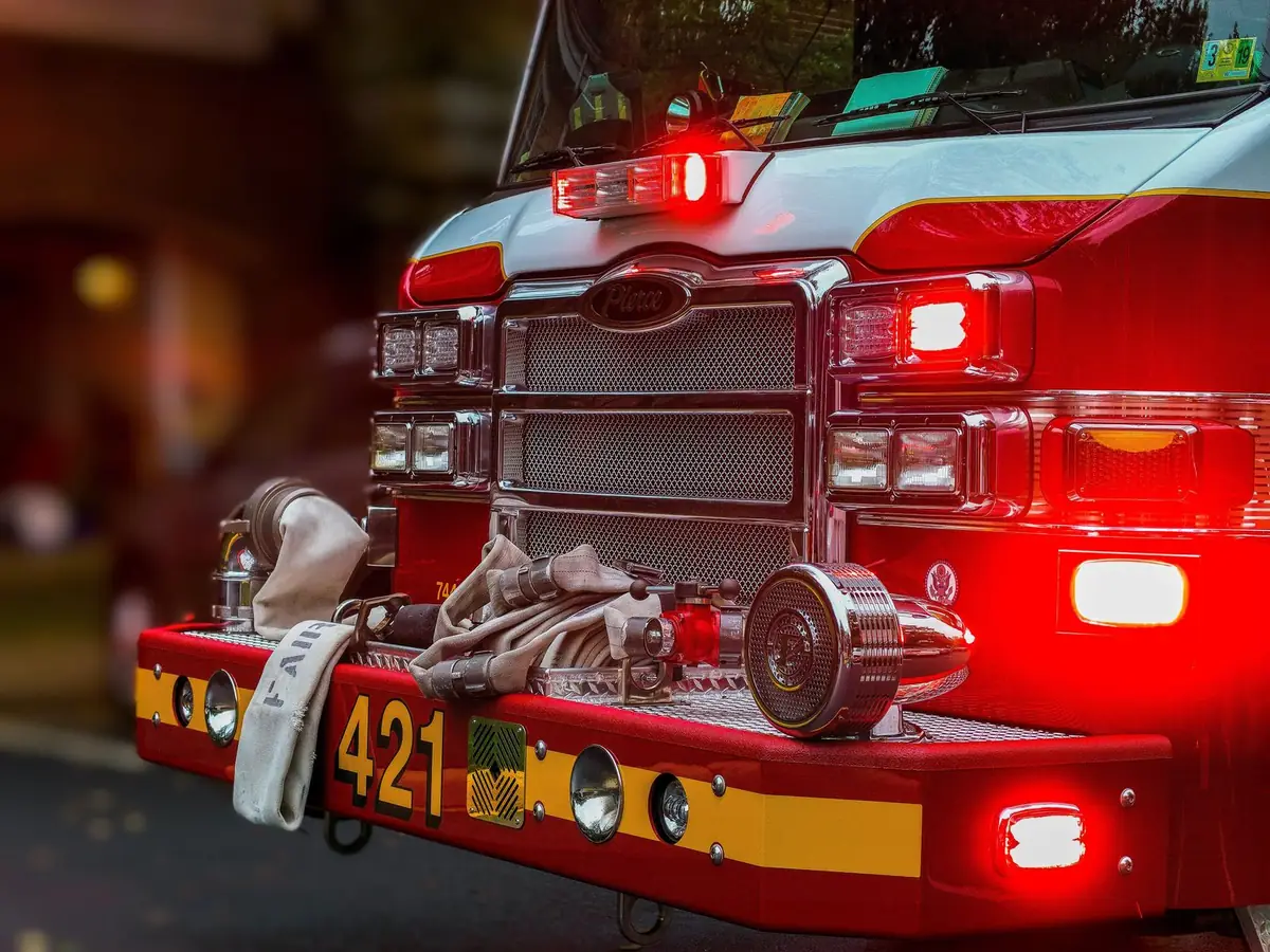 Close-up of a fire truck front with hoses and flashing lights